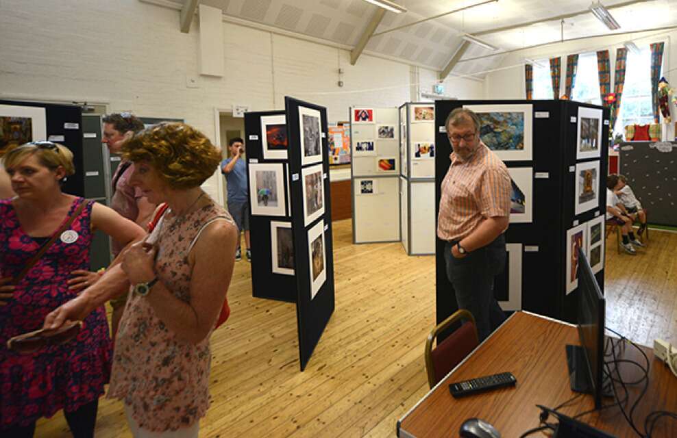 Visitors look at photographs on exhibition stands.