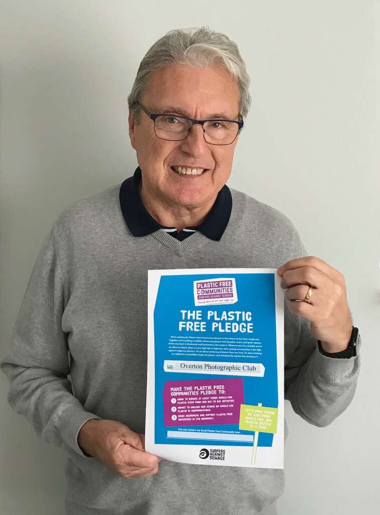 Stan stands holding the signed, Plastic Free Pledge certificate from Surfers Against Sewage.